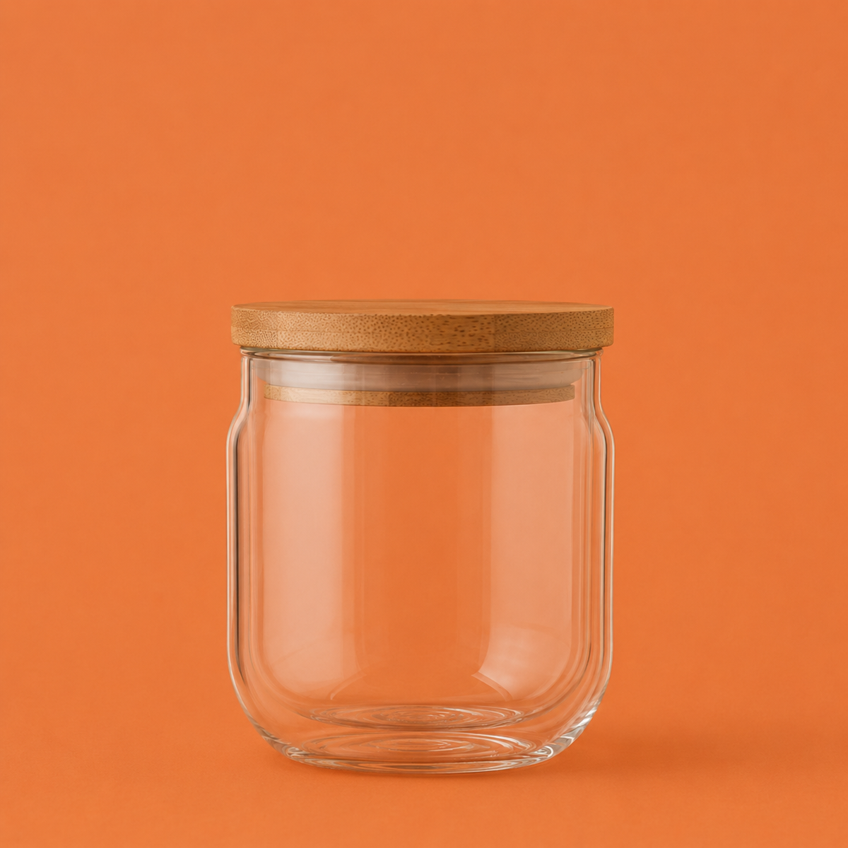 Clear glass jar with a wooden lid on an orange background