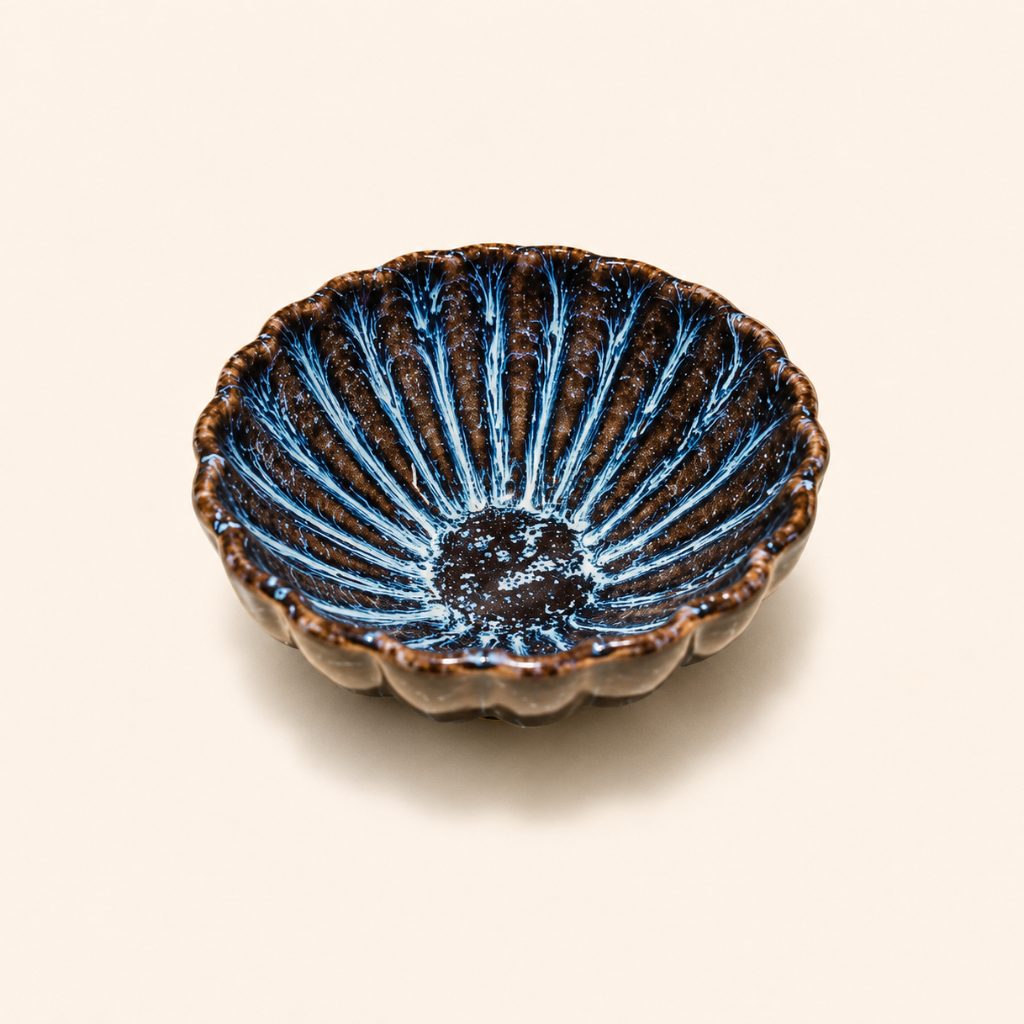 Ceramic bowl with blue and brown glaze on a beige background