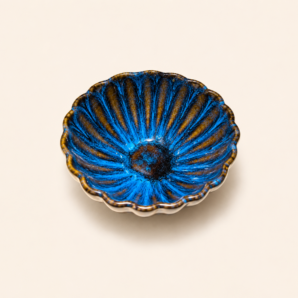 Blue ceramic dish with gold accents on a beige background