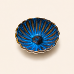 Blue ceramic dish with gold accents on a beige background