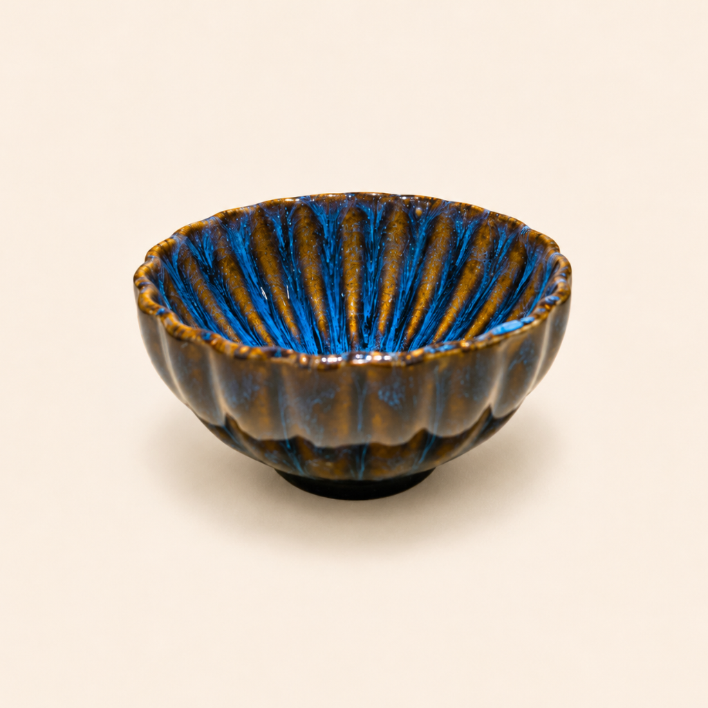 Ceramic bowl with blue interior and brown exterior on a beige background