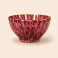 Pink ceramic bowl with textured surface on a beige background