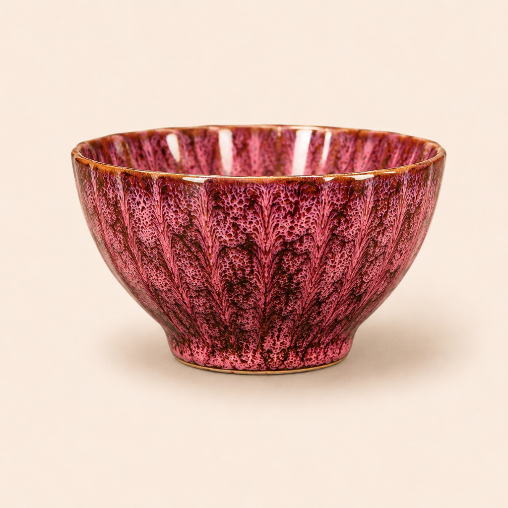 Pink ceramic bowl with textured surface on a beige background