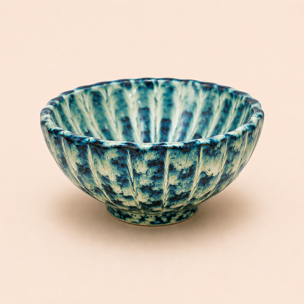 Blue and green ceramic bowl on a beige background