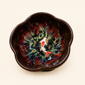 Ceramic bowl with artistic fish design on a beige background
