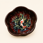 Ceramic bowl with artistic fish design on a beige background