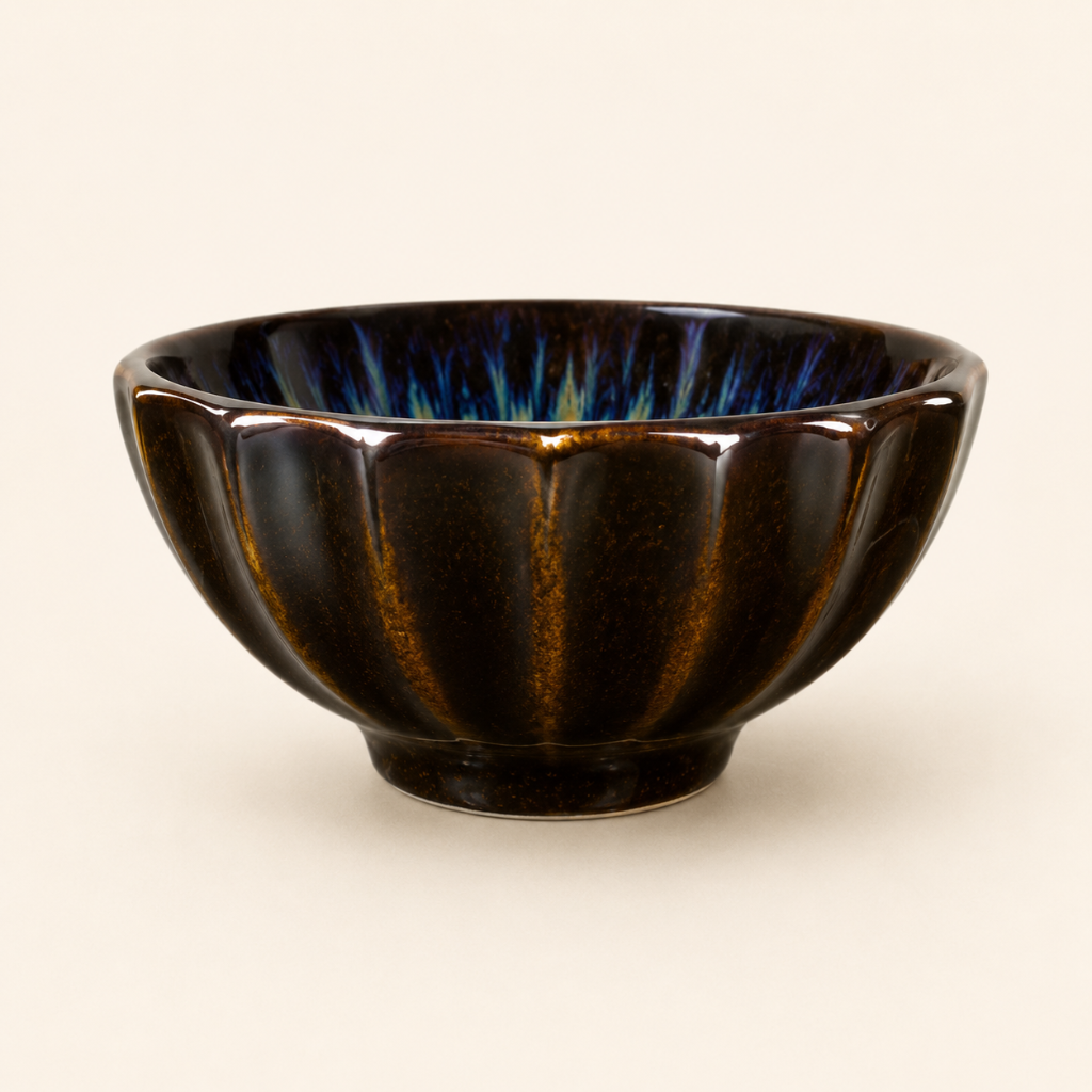 Black ceramic bowl with ribbed texture on a beige background