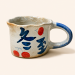 Ceramic mug with blue and red designs on a white background