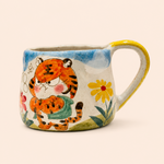 Ceramic mug with tiger design and floral elements on a beige background
