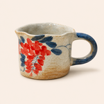 Ceramic mug with floral design on a beige background