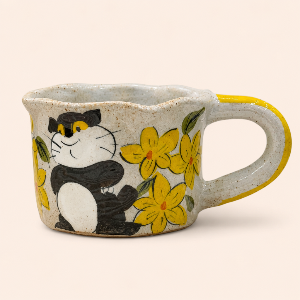 Ceramic mug with a cat and flower design on a beige background