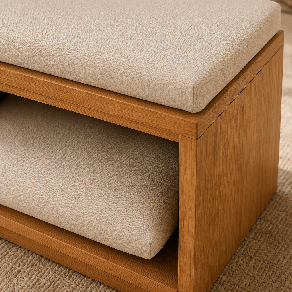 Close-up of a wooden bench or storage ottoman with thick beige upholstered seat and lower cushion, shown on a textured rug.