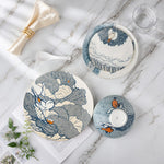 Set of ceramic plates with bird designs on a marble surface