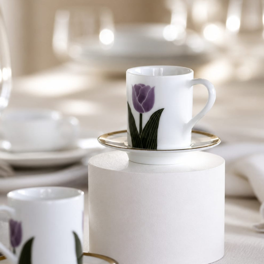 White ceramic cup with purple tulip design on a white pedestal