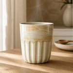 Steaming ceramic mug on a wooden surface with a blurred background