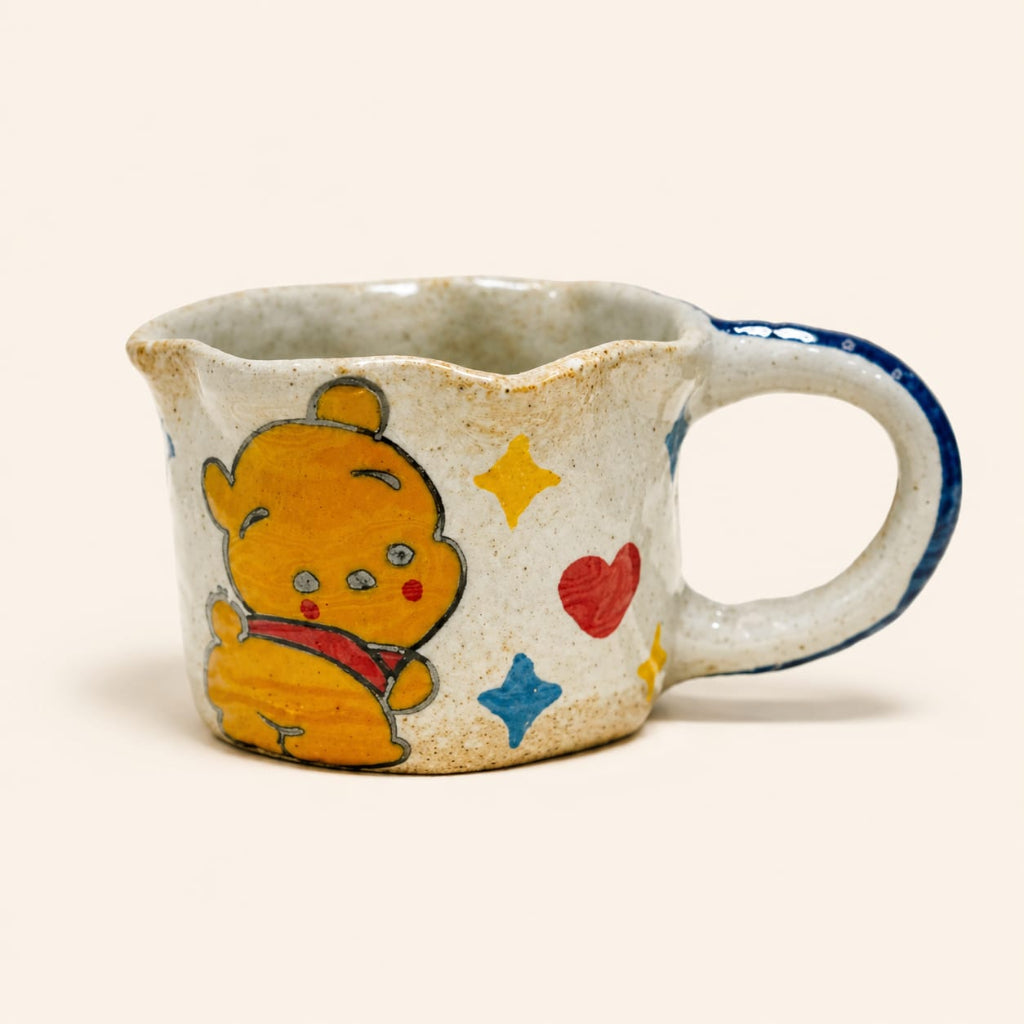 Ceramic mug with a cartoon bear design on a beige background