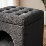 A dark gray tufted storage ottoman with a textured bouclé-like fabric, shown in a close-up view highlighting the button tufting and the side arch opening.